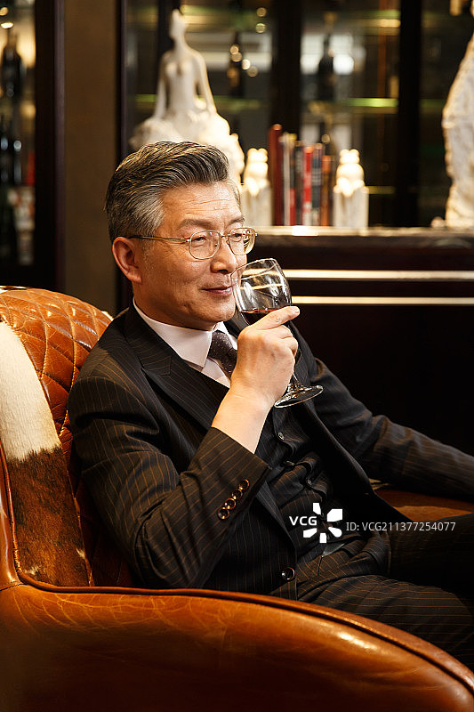 成功的商务男人在喝红酒图片素材