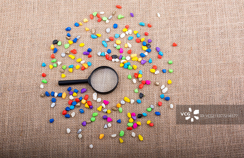 彩色珠子和粗麻布上的放大镜高角度视图图片素材