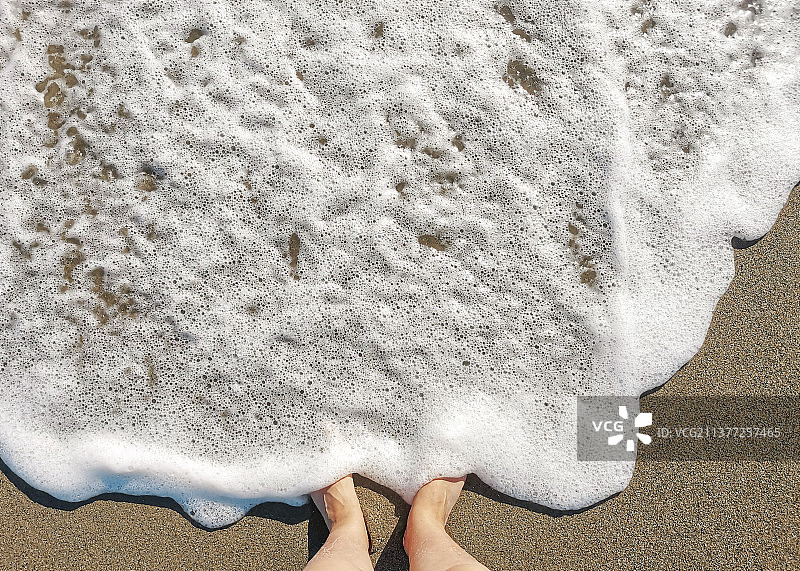沙滩上被海浪冲刷的赤脚图片素材