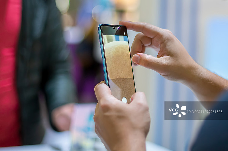 白人男子手持新款旗舰智能手机并测试相机图片素材