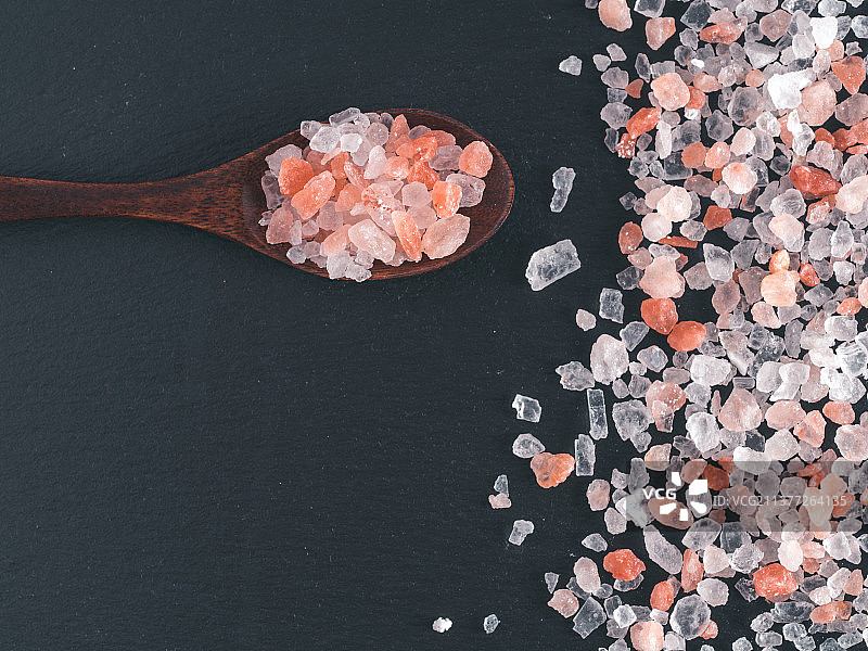 喜马拉雅粉盐晶体，桌子上盐和勺子的高角度视图图片素材