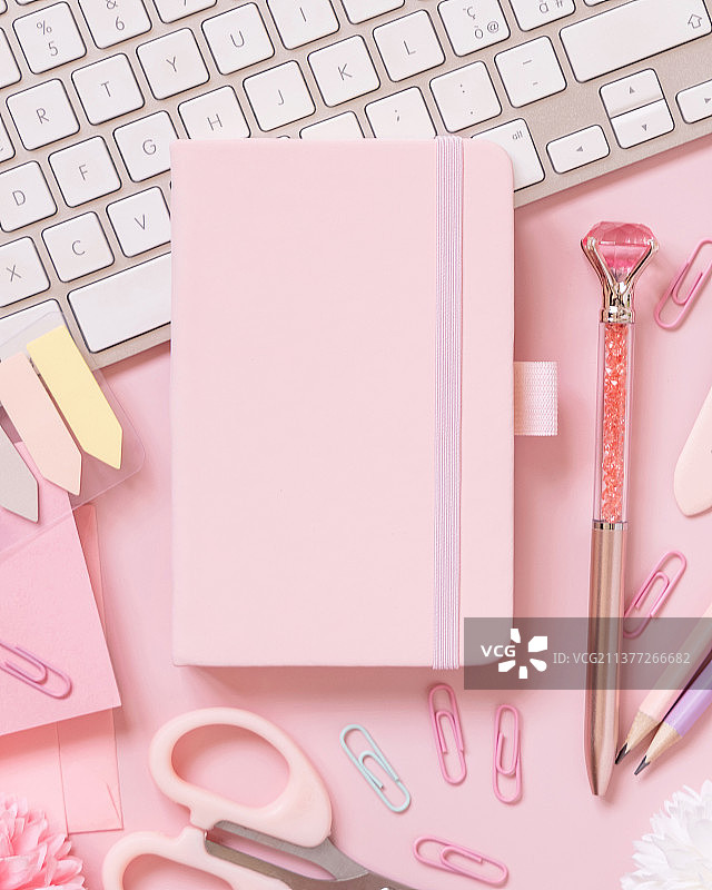 粉色背景上的笔记本、粉色配饰和键盘样机图片素材