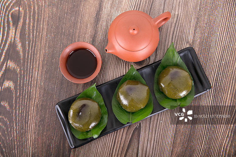 一盘清明节的食物糯米艾草青团子和喝茶茶具图片素材