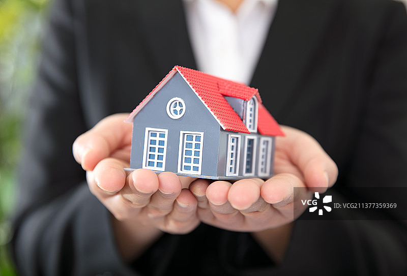 正装女性手捧着小房子模型图片素材