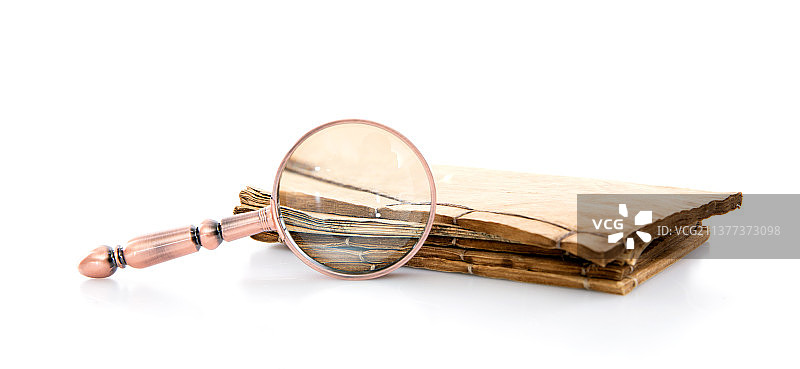 白背景上的旧书和放大镜图片素材