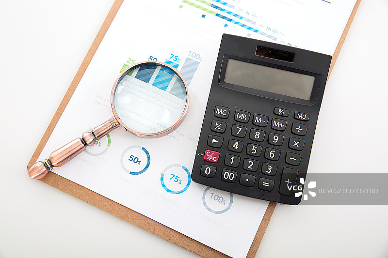 金融文件上的放大镜和计算器图片素材