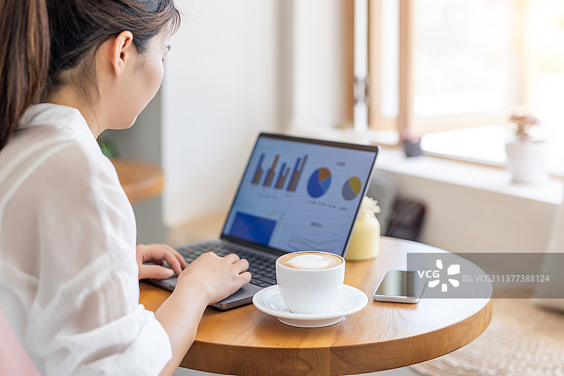 商务青年女子在咖啡馆使用笔记本电脑工作喝咖啡图片素材
