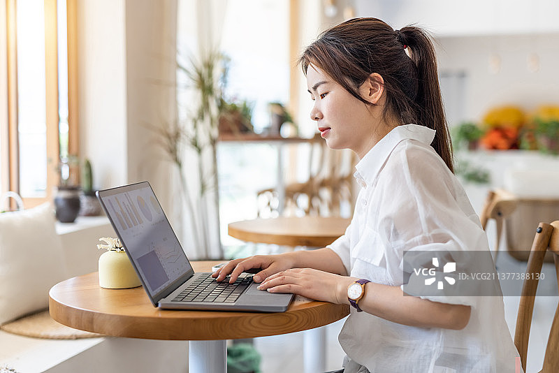 商务青年女子在咖啡馆使用笔记本电脑工作喝咖啡图片素材