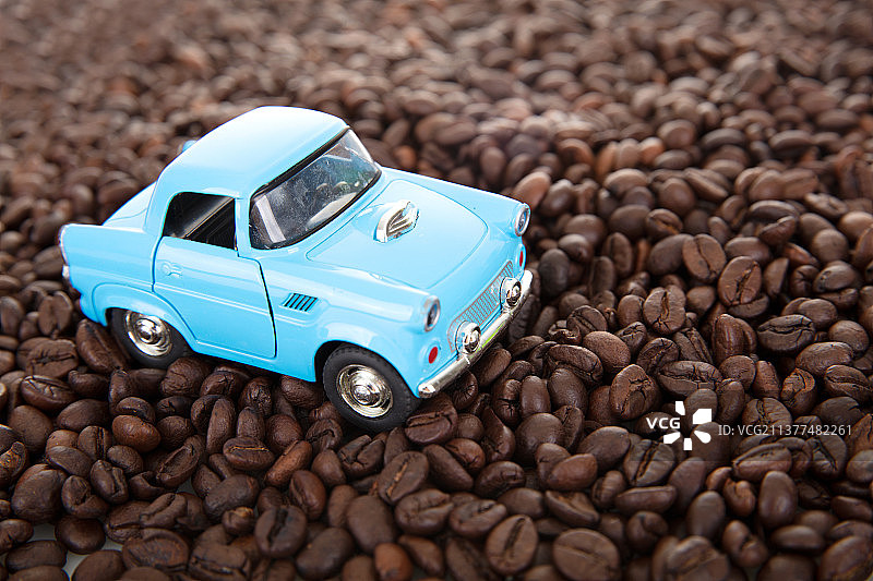行驶在一堆咖啡豆上的小汽车模型图片素材