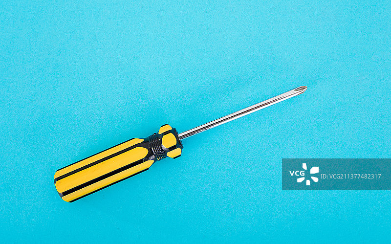 俯视蓝色背景上一个改锥工具图片素材