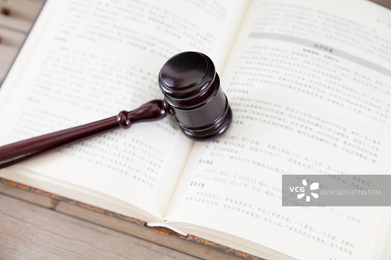 俯视桌子上一本翻开的书和书上一个法锤图片素材