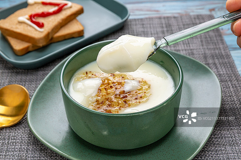 用勺子舀起一勺双皮奶特写图片素材