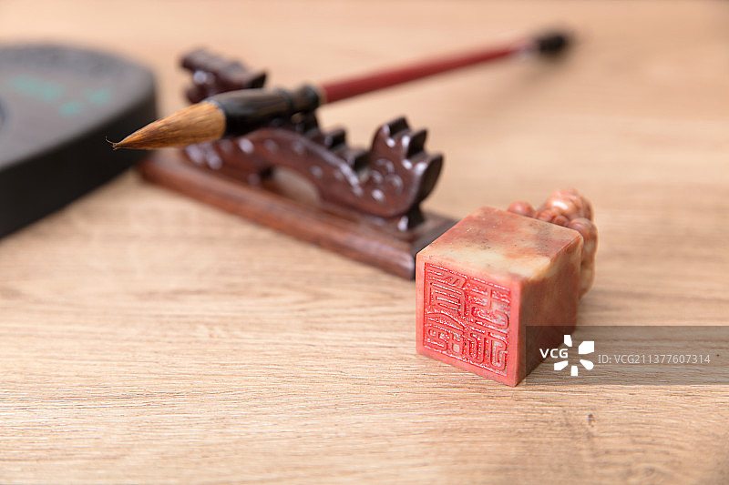 笔托上放着毛笔及旁边的印章和砚台图片素材