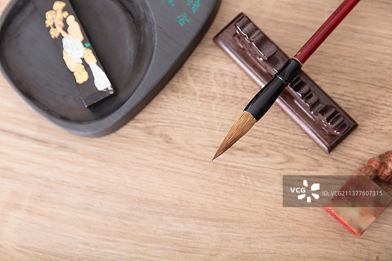 笔托上放着毛笔及旁边的印章和砚台图片素材