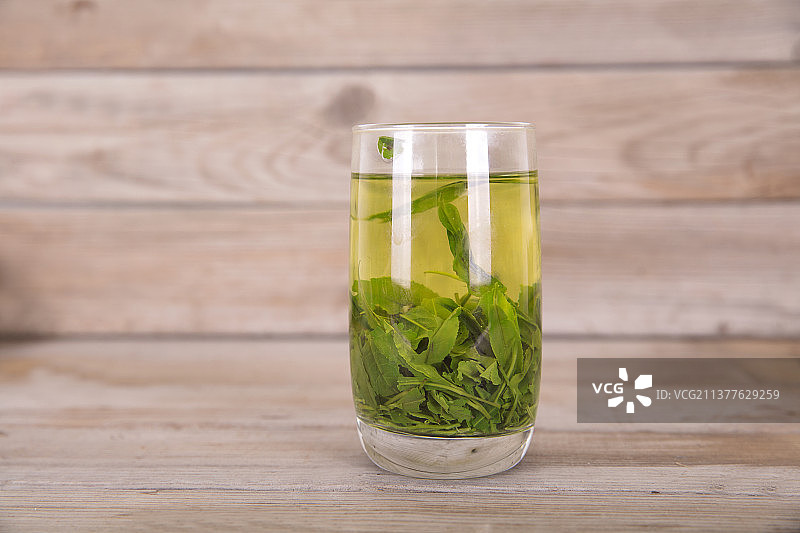 木质桌子上一杯刚泡好的绿茶图片素材