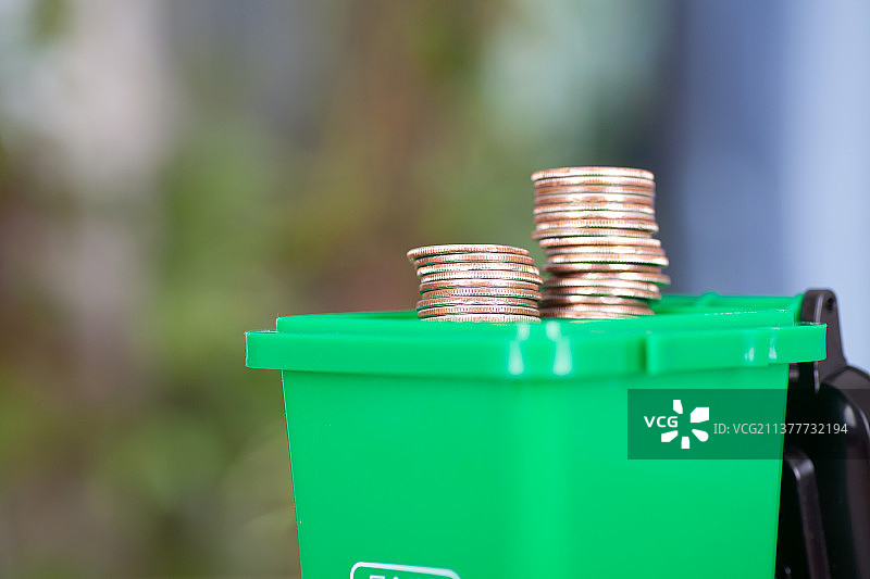 掀开盖子冒出美元硬币的绿色垃圾桶模型图片素材