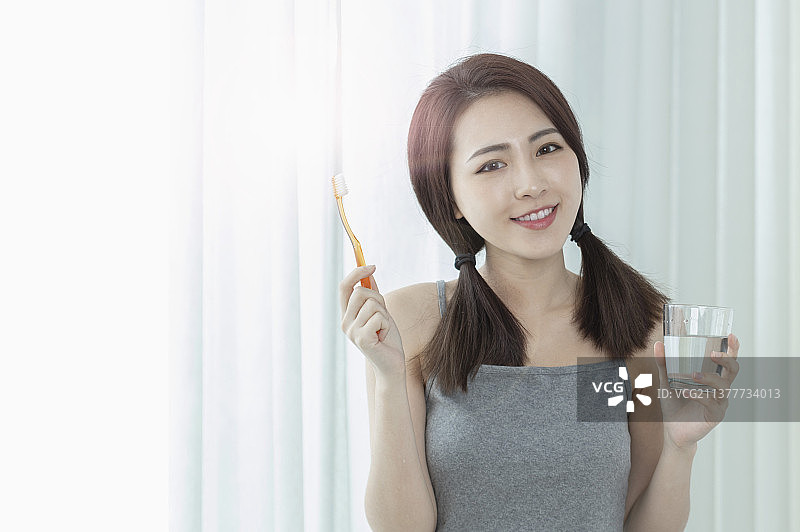 东方美女拿着牙刷微笑图片素材