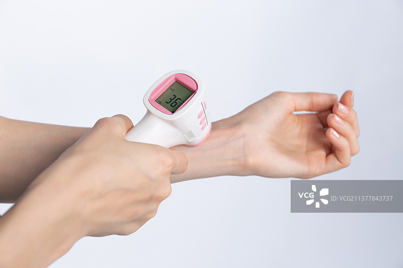 使用电子温度计测量手腕上的温度图片素材