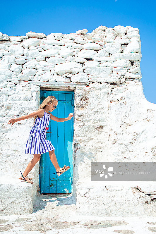 在米科诺斯街头玩耍的女孩们（蓝色连衣裙）图片素材