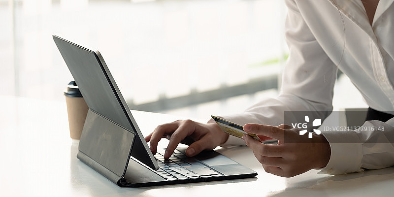 女孩用平板电脑在网上购物特写图片素材