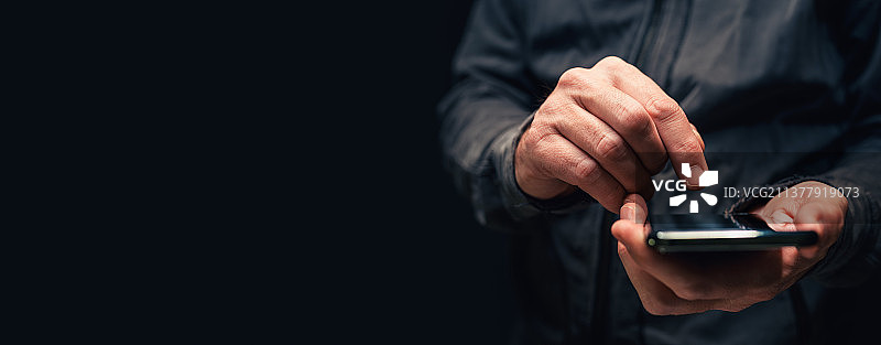 塞尔维亚：黑色背景上使用智能手机的男性手部特写图片素材