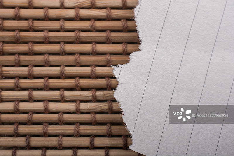 稻草背景上的破损纸张图片素材