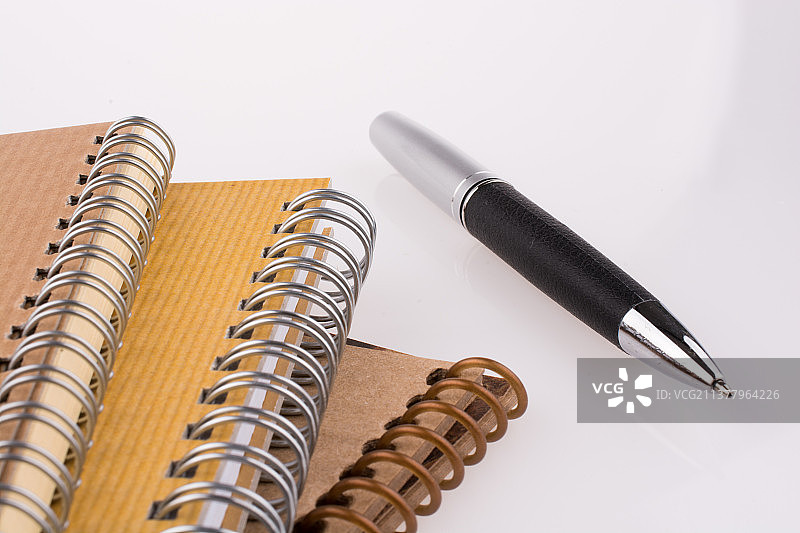 白色背景上的螺旋笔记本和笔特写图片素材