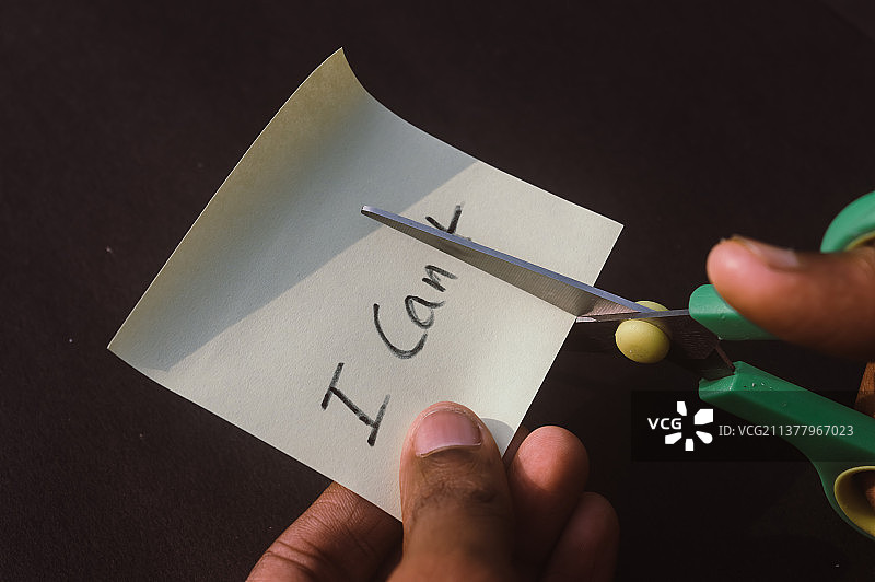 用剪刀剪切写在矩形纸上的字母T图片素材