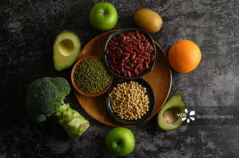 黑色水泥地面上的豆类和水果图片素材