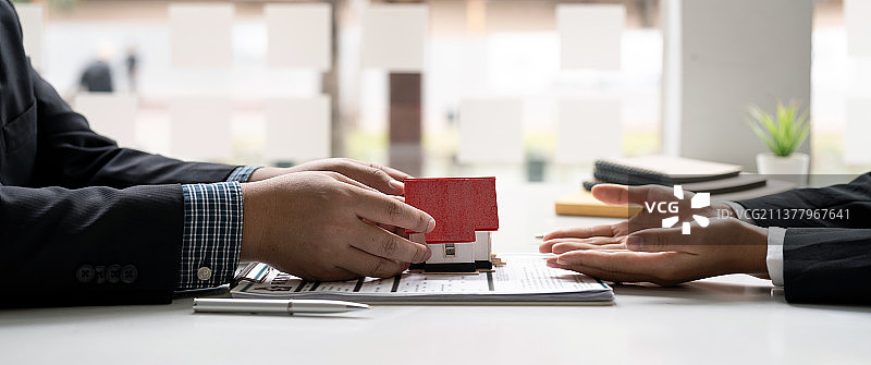房产中介同意购房并将房屋模型交给客户图片素材