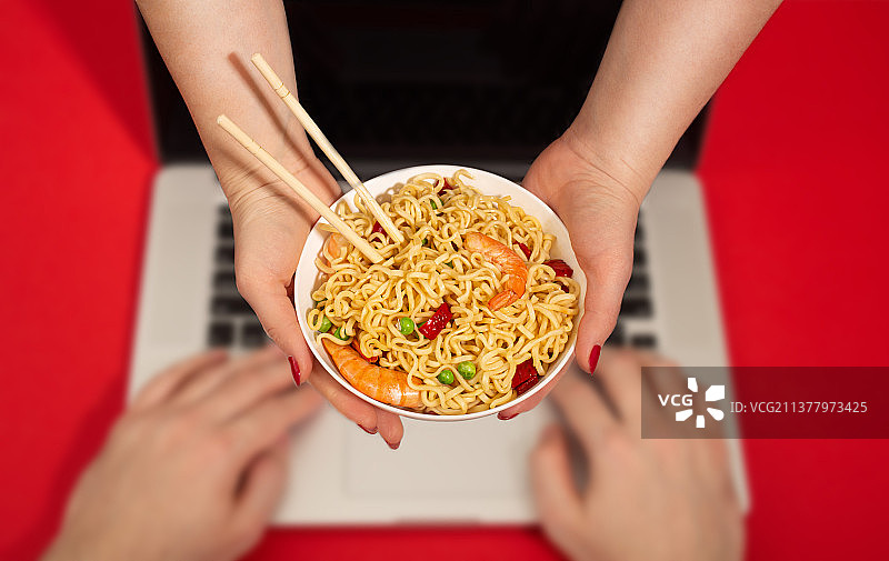 女快递员把面条递给在电脑前的男人，外卖配送图片素材