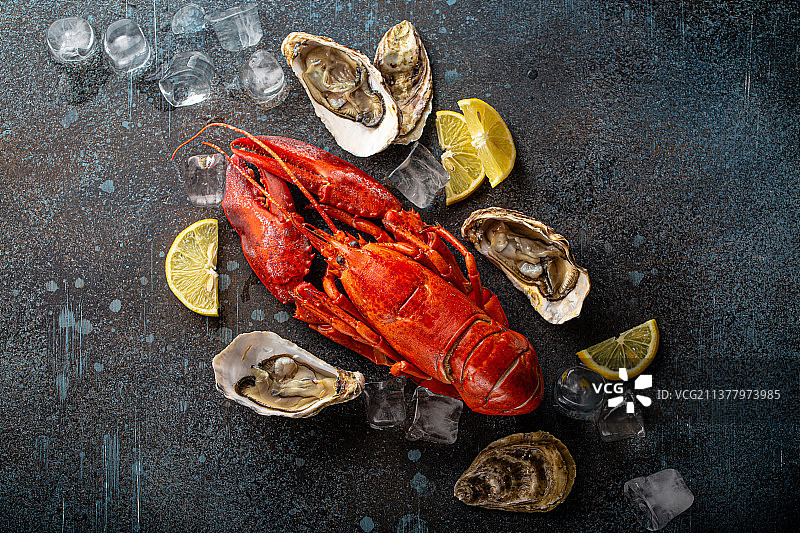 蓝石板上的龙虾、生蚝、柠檬和冰块图片素材