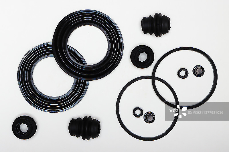 白色背景上的黑色橡胶垫圈、环、油封、机器维修零件（高角度拍摄）图片素材