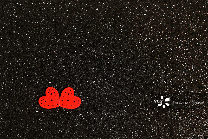黑色闪亮背景上的两个心形图片素材