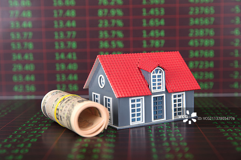 金融数据背景上一卷日元纸币和一个小房子模型图片素材