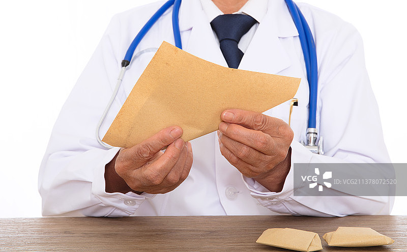 穿着白大褂的大夫在用草纸把药包起来图片素材