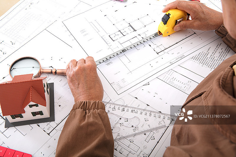 俯视拍摄建筑设计师使用卷尺测量图纸图片素材