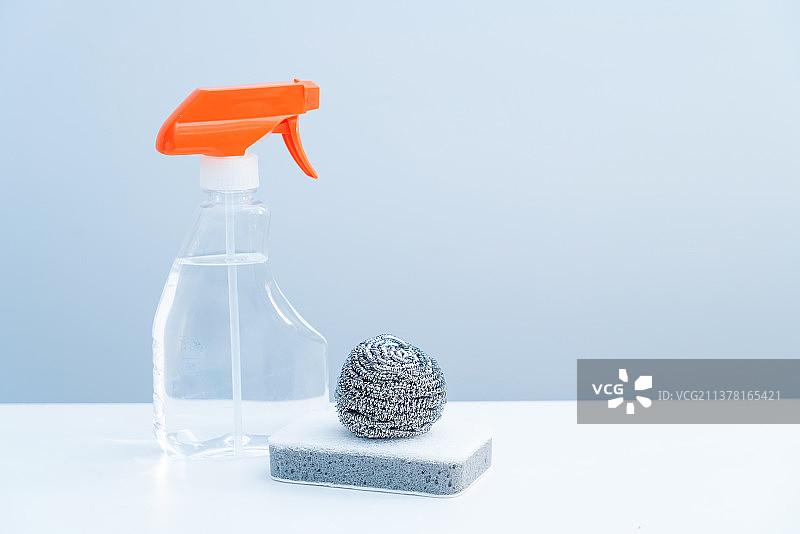 一瓶透明的清洁剂和清洁球放在白色桌面上图片素材