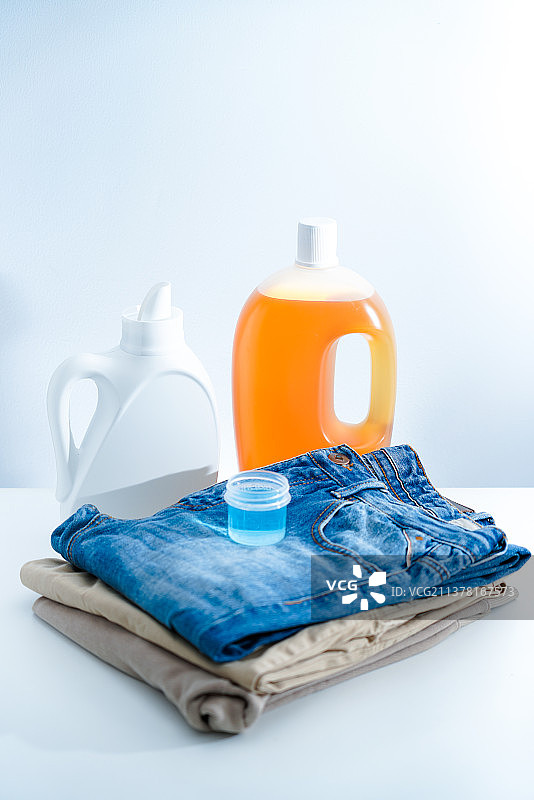一瓶洗衣液和衣物消毒液放在白色桌面上图片素材
