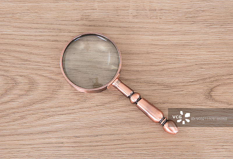 一个普通的放大镜在桌子上图片素材