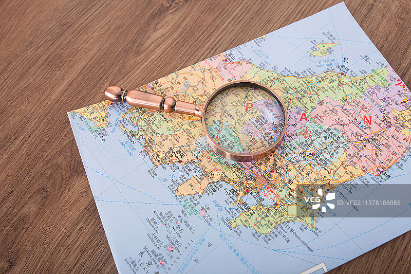 日本旅游地图和一把放大镜图片素材