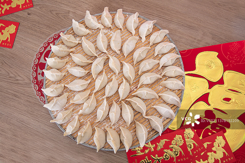 包好的白面饺子和金字春联及节日的红包图片素材