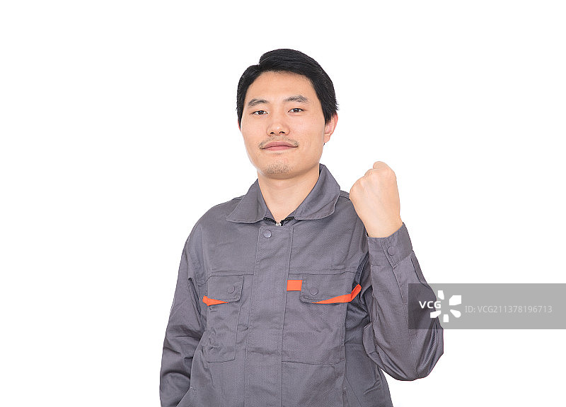 白背景前握拳抬手给自己鼓气的年轻工人图片素材