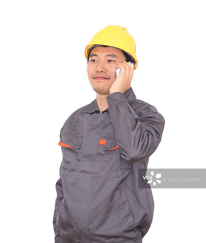 白背景前头戴黄色安全帽的农民工在往家里打电话图片素材