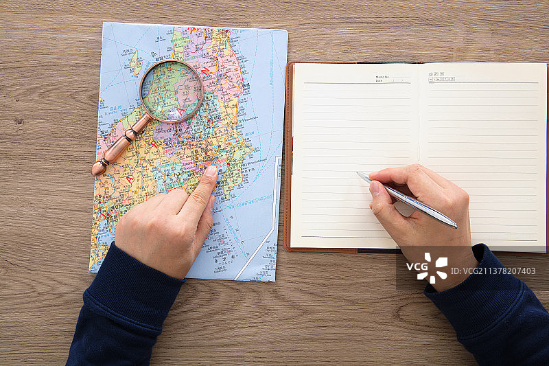 旅行者对着日本地图在做旅游计划图片素材