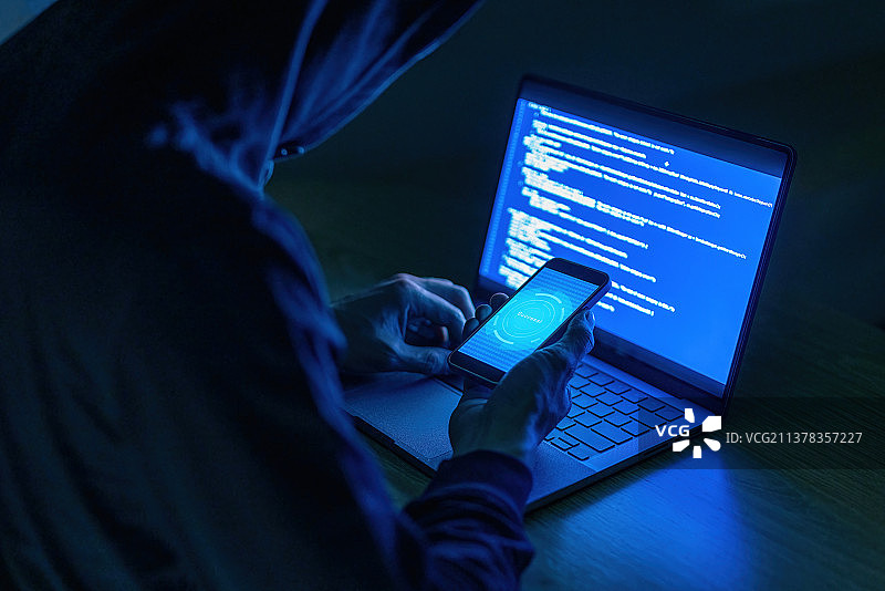 黑客使用笔记本电脑攻击网络破解手机图片素材