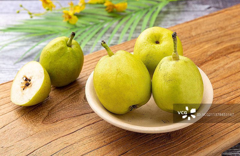 木板上盘子里的新疆库尔勒香梨图片素材