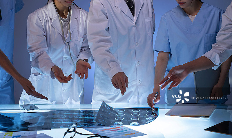 医务工作者用手指着X光片讨论研究图片素材