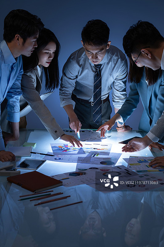 看着报表做工作分析的商务团队图片素材