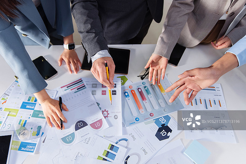 商务人士拿着铅笔指着报表分析研究图片素材